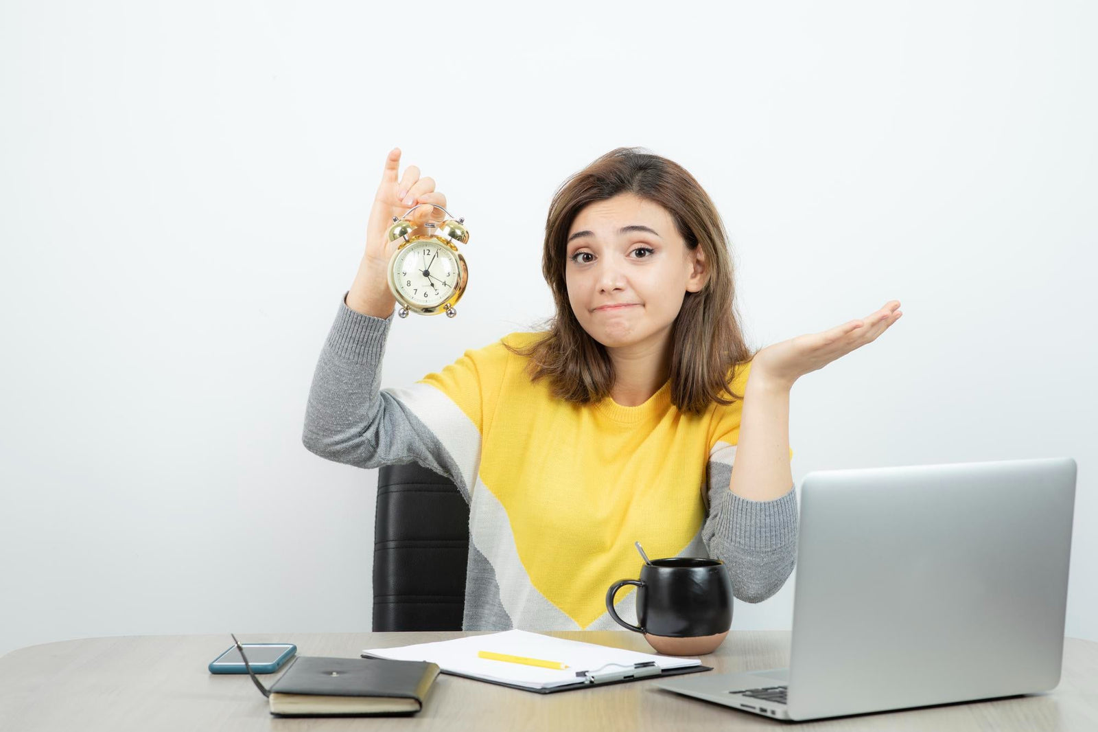 A frustrated sales professional holding up an alarm clock at her desk, symbolizing the time wasted by chasing unqualified merchant cash advance leads